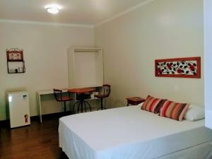a bedroom with a white bed and a desk at Hotel Pousada Riacho da Areia in Águas de Lindóia +274 photos