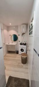 biała łazienka z umywalką i pralką w obiekcie LE MANGUIER w mieście Baie-Mahault