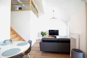 - un salon avec un canapé noir et une table dans l'établissement Coco Elaura Modern Duplex with 2 Bedrooms and a Balcony in Biarritz, à Biarritz