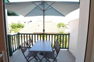 d'une table bleue, de chaises et d'un parasol sur le balcon. dans l'établissement Coco Elaura Modern Duplex with 2 Bedrooms and a Balcony in Biarritz, à Biarritz
