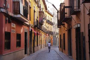 a man walking down a street in an alley at Niños Luchando in Granada