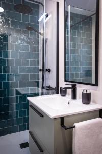 a bathroom with a sink and a shower with blue tiles at Niños Luchando in Granada +26 photos