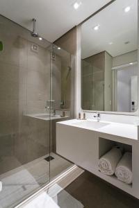 a bathroom with a sink and a glass shower at DMax Hotel in Marília