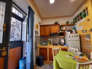 a kitchen with a table with a green table cloth on it at Il Sole della Guilla in Palermo
