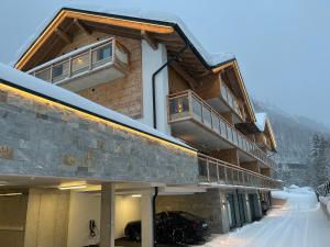 a building with snow on the ground in front of it at ALPIUM - Luxusappartements in Flachau