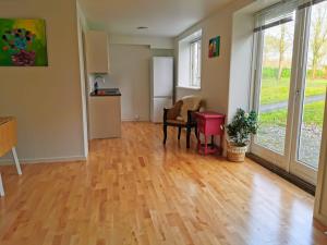 an empty living room with wooden floors and windows at 300meter walk to LEGO house - 70m2 apartment with garden in Billund