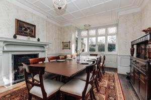 a dining room with a table and chairs and a fireplace at Waterfront Retreat in Henley on Thames