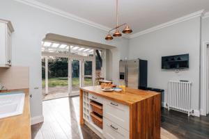 a kitchen with white cabinets and a wooden counter top at Waterfront Retreat in Henley on Thames