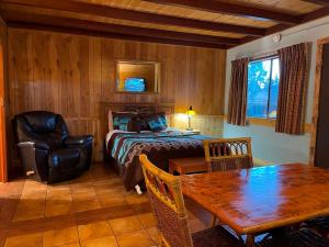 um quarto com uma cama, uma mesa e uma cadeira em West Winds Lodge em Ruidoso