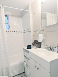 a white bathroom with a sink and a tub at Royal Sunshine in New Orleans