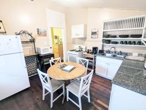 a kitchen with white appliances and a wooden table at Royal Sunshine in New Orleans