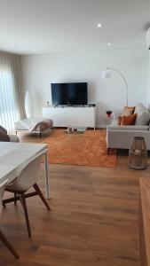 een woonkamer met een bank en een tv bij Veronique Apartment in Nazaré