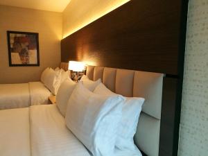 a hotel room with two beds with white pillows at Holiday Inn Guatemala, an IHG Hotel in Guatemala