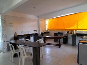 a large kitchen with a table and chairs in it at Pousada Milton in Angra dos Reis