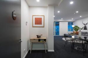 uma sala de estar com uma mesa e uma sala de jantar em Melbourne South Yarra Central Apartment Hotel Official em Melbourne
