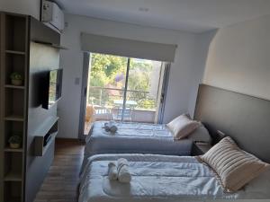 two beds in a room with a balcony at Aires de Capital Depto in Salta