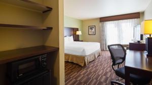 a hotel room with a bedroom with a bed and a desk at Best Western Sundowner in Sterling
