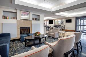 een lobby met een open haard, stoelen en een tafel bij Best Western Chesapeake Bay North Inn in North East