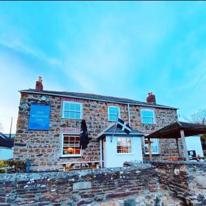 un edificio de piedra con una señal azul en The Wilcove Inn, en Torpoint