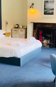 een bed in een kamer met een open haard bij The Wilcove Inn in Torpoint