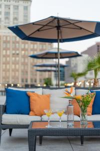 ein Tisch mit zwei Gläsern und einem Sonnenschirm auf einer Terrasse in der Unterkunft NOPSI Hotel New Orleans in New Orleans