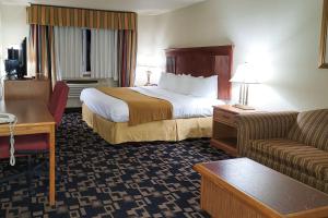 Comfort Inn & Suites في شاكوبي: غرفه فندقيه بسرير واريكه