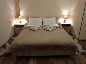 a bedroom with a large bed with two night stands at La Maison #7 in Tbilisi City