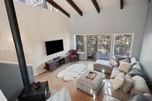 a living room with a couch and a flat screen tv at Pet Friendly Pine Knoll Home in Bend +21 photos