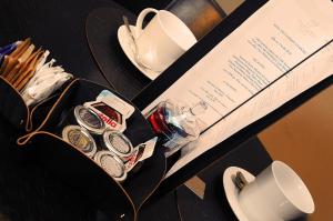a table topped with plates and cups and a box at Borghese Palace Art Hotel in Florence