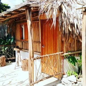 une petite cabane avec toit de chaume dans l'établissement Cabañas Alma Verde, à Bacalar