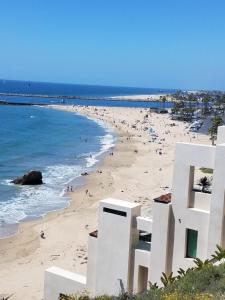 una playa con un edificio blanco y gente en ella en CLOUD NINE - Comfort & Elegance, en Irvine