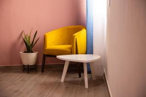 una silla amarilla y una mesa blanca en una habitación en Hotel Casa Jima Agave en Tequila