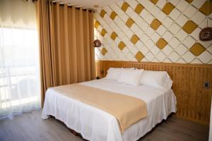 a bedroom with a large white bed with a large window at Hotel Casa Jima Agave in Tequila