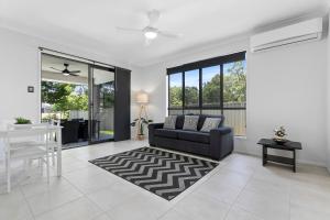 a living room with a couch and a table at Bribie Getaway Villa in Bongaree