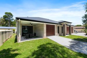 a brick house with a black roof at Bribie Getaway Villa in Bongaree