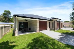 une maison en briques avec un toit noir dans l'établissement Bribie Getaway Villa, à Bongaree