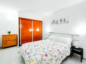 1 dormitorio blanco con 1 cama y armario de madera en Cozy Beach Holiday Home in Playa del Ingles, en Playa del Inglés