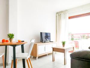 A television and/or entertainment centre at Cozy Beach Holiday Home in Playa del Ingles