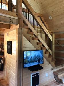 a living room with a tv in a wooden cabin at Cozy Cabin Near Grayson Highlands State Park in Whitetop