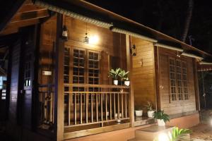 Munroe IslandGreenChromide Homestays的门廊上种有盆栽植物的木屋