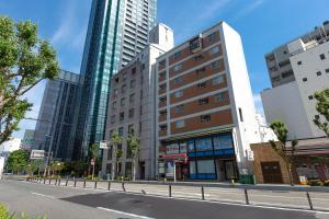 een straat in een stad met hoge gebouwen bij Ideal Fukushima in Osaka
