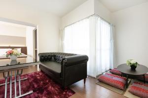 een woonkamer met een leren bank en een tafel bij Ideal Fukushima in Osaka