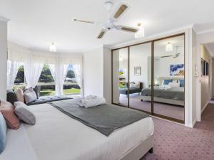 sypialnia z dużym łóżkiem i dużym lustrem w obiekcie Rose Retreat w mieście Port Fairy