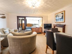 a living room with a couch and a television at Sea-Prize View in Colwyn Bay