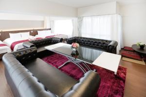 een woonkamer met lederen meubels en een bank bij Ideal Fukushima in Osaka