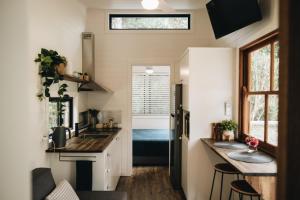 uma cozinha com dois lavatórios numa pequena casa em Maclean River Front Tiny House - Clarence Valley Tiny Homes em Maclean