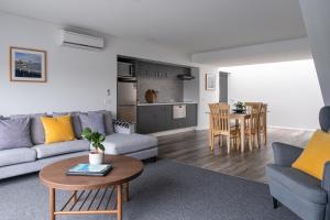 a living room with a couch and a table at Corrigans Cove Resort Batemans Bay in Batemans Bay