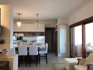Una cocina y una sala de estar con mesa y sillas. en Beautiful Villa with Private Pool by Beahost, en Isola Albarella