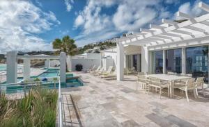 a patio with a table and chairs next to a pool at The Luxury Villa in Saint Martin