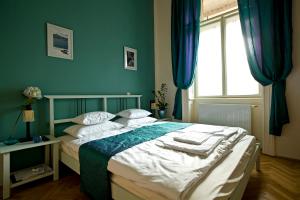 Budapest Rooms Bed and Breakfast في بودابست: غرفة نوم بسرير والجدران الزرقاء ونافذة